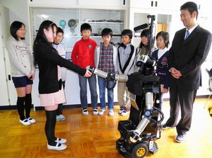 ロボビーに話しかけ、握手をする子どもたち=精華町光台7丁目
