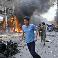 29日、パキスタンのペシャワルで、爆発の現場から逃げる住民(AP)